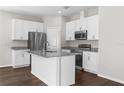 Modern kitchen featuring white cabinets, stainless steel appliances, granite countertops, and a center island at 9062 Wade St, Brooksville, FL 34613