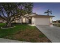 Charming single-Gathering home featuring a well-manicured lawn, mature trees, and a two-car garage at 9336 Creekside Ct, Hudson, FL 34669