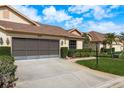 Single Gathering home featuring a two car garage, tidy landscaping, and a well maintained lawn at 9405 Palm Haven Ct, New Port Richey, FL 34655