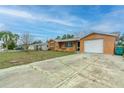 A quaint single-story home with an attached garage and a spacious concrete driveway at 10736 Queens Rd, Port Richey, FL 34668