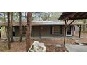 View of the back of the home; exterior of this home features a neutral color palette and wooded surroundings at 11617 Duda Rd, Hudson, FL 34667