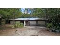 Attached two car garage with potential; the exterior of this home is surrounded by mature trees at 11617 Duda Rd, Hudson, FL 34667