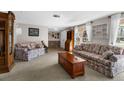 Cozy living room with neutral carpet, large windows, and comfortable seating, creating an inviting atmosphere at 12511 Stone House Loop, Hudson, FL 34667