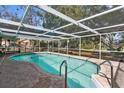 Inviting in-ground pool with screened enclosure, perfect for outdoor entertaining and relaxation at 12511 Stone House Loop, Hudson, FL 34667