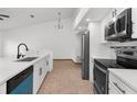 Updated kitchen featuring stainless steel appliances, sleek countertops and backsplash, with white cabinets and modern fixtures at 1382 Aladdin Rd, Spring Hill, FL 34609