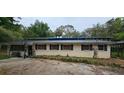 A single-story home with mature trees and a dark-colored roof at 17932 Wendy Sue Ave, Hudson, FL 34667