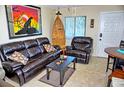 Comfortable living room with tile floors, brown leather furniture, and natural light at 20857 Haulover Cv # B15, Lutz, FL 33558