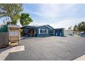 Charming blue home featuring white shutters, a small porch, and ample parking space in front at 291 115Th Ave, Treasure Island, FL 33706