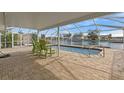 Screened-in pool with a clear water view and outdoor seating, perfect for enjoying the waterfront scenery at 3328 Gulfview Dr, Hernando Beach, FL 34607