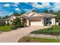 Gorgeous single-story home featuring a brick-paved driveway and beautiful landscaping at 5383 Firethorn Pt, Spring Hill, FL 34609