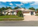 Charming single-story home boasting lush landscaping, an American flag, and a brick-paved driveway at 5383 Firethorn Pt, Spring Hill, FL 34609