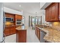 Well-equipped kitchen features granite countertops, stainless steel appliances, and breakfast nook at 6413 Emerson Rd, Brooksville, FL 34601
