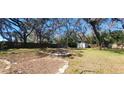 This backyard features a fire pit and large trees at 6825 Main St, New Port Richey, FL 34653