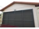 Close-up view of the garage featuring an address and a textured exterior at 7308 Mako Dr, Hudson, FL 34667