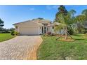 Attractive single-story home boasts a brick driveway, manicured lawn, and a welcoming, well-lit entrance at 8910 Jericho Rd, Weeki Wachee, FL 34613