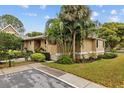 A view of the home's exterior showcasing mature landscaping, a front entrance, and ample parking at 1002 Caravel Ct, Tarpon Springs, FL 34689