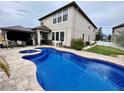 An inviting backyard pool with a spa, covered patio, and lush landscaping at 11611 Lake Blvd, New Port Richey, FL 34655