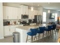 Modern kitchen with granite countertops, stainless steel appliances and stylish island seating at 15384 Caravan Ave, Odessa, FL 33556