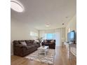 Bright living room with two couches, white rug and table, and a mounted TV at 19325 Water Oak Dr # 205, Port Charlotte, FL 33948