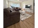 Living room features two couches, a white rug and table, and a mounted TV at 19325 Water Oak Dr # 205, Port Charlotte, FL 33948