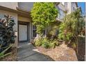 Inviting home entrance with beautiful, lush landscaping and a well-lit doorway with a white door at 2764 Countryside Blvd # 3, Clearwater, FL 33761