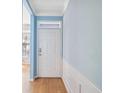 Charming entryway with a white door, light blue walls, white trim, and beautiful wood floors at 2764 Countryside Blvd # 3, Clearwater, FL 33761