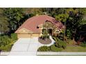 Attractive single-story home with terracotta roof tiles, complemented by mature landscaping and a spacious driveway at 2806 Grey Oaks Blvd, Tarpon Springs, FL 34688
