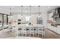 Spacious white kitchen featuring stainless steel appliances, pendant lighting, and a large island at 3130 Forsythia Dr, Odessa, FL 33556