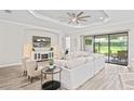 Bright living room with modern decor, a ceiling fan and sliding glass doors to the patio at 3130 Forsythia Dr, Odessa, FL 33556
