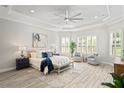 Inviting primary bedroom featuring tray ceilings, plantation shutters, and ample natural light at 3130 Forsythia Dr, Odessa, FL 33556