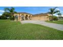 Beautiful tan home with a well-manicured lawn, palm trees, and an attached three-car garage at 3542 Conifer Loop, Spring Hill, FL 34609