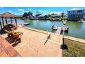 Paver patio with canal views, featuring a dock, outdoor seating, and a charming gazebo at 4048 Orient Dr, Hernando Beach, FL 34607
