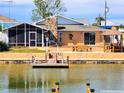Waterfront home with a screened in lanai, stone chimney and a dock, perfect for enjoying outdoor living at 4048 Orient Dr, Hernando Beach, FL 34607