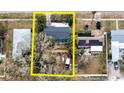 Aerial view of a home with a dark shingled roof and lush landscaping. The backyard has an under construction vibe at 506 8Th Ave Sw, Largo, FL 33770