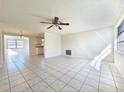 Bright living room with large windows and tile floors, leading into the kitchen at 7421 San Miguel Dr, Port Richey, FL 34668