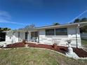 Well-maintained single-story home featuring a beautifully landscaped front yard with decorative rock and a welcoming porch at 7535 Valencia Ave, Port Richey, FL 34668