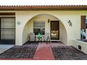 Covered front porch with seating and a well manicured landscape and unique architecture at 8110 Bismark Ct, Port Richey, FL 34668