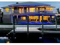 Gorgeous waterfront home featuring blue underlighting, a dock, and a lanai, perfect for evening relaxation at 8401 Carolyn Dr, Port Richey, FL 34668