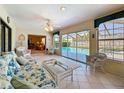 Cozy sunroom featuring tile floors, large windows with a sliding glass door providing pool views at 8711 Woodmont Ln, Port Richey, FL 34668