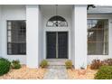 Close up of the double door entryway flanked by decorative windows at 9397 Merriweather Dr, Weeki Wachee, FL 34613