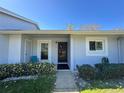 Charming front entrance with a blue exterior, lush landscaping, and clear windows at 12205 Darwood Dr # 12205, Hudson, FL 34667