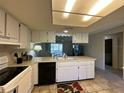 Functional kitchen featuring white cabinetry, a breakfast bar, and a seamless connection to the living area at 12205 Darwood Dr # 12205, Hudson, FL 34667