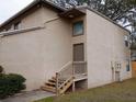 Exterior view of a townhouse, featuring a private entrance with wooden steps at 12401 Joel Ct, Tampa, FL 33612
