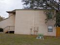 Exterior side view of a townhouse with stairs, electrical boxes, and a small window at 12401 Joel Ct, Tampa, FL 33612