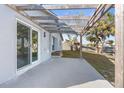 Relaxing back patio with modern pergola, leading to the waterfront backyard with mature palm trees at 13726 Michelle Ave, Hudson, FL 34667