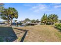 Waterfront backyard with lush palms, boat lift, and serene views of canal at 13726 Michelle Ave, Hudson, FL 34667