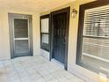Inviting front entrance with secure black door, tiled floor, and framed windows for natural lighting at 14736 Norwood Oaks Dr # 103, Tampa, FL 33613