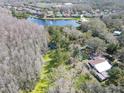 Scenic aerial view of a home nestled amidst lush greenery, nearby lake, and surrounded by a serene neighborhood setting at 14821 Sassandra Dr, Odessa, FL 33556