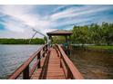 Waterfront home featuring a private dock with a covered seating area for relaxing by the water at 1616 Sea Breeze Dr, Tarpon Springs, FL 34689