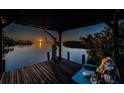 Scenic sunset view from the covered dock with boat lift and inviting chair at 1616 Sea Breeze Dr, Tarpon Springs, FL 34689